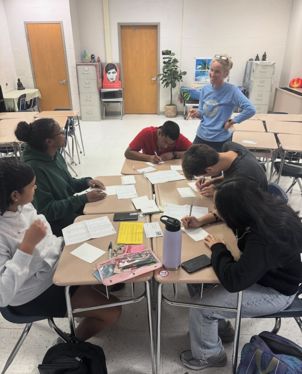 Club sponsor Holly Miller advises Lewis SDA students as they write postcards urging swing state voters to vote.